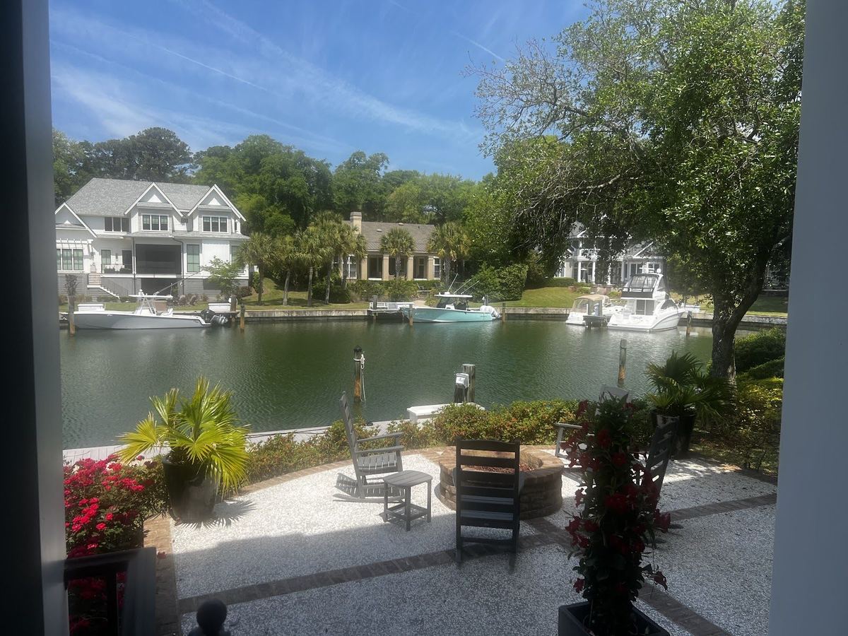 Waterfront patio with gravel seating area and colorful planters, landscaped by Prestige Landscaping
