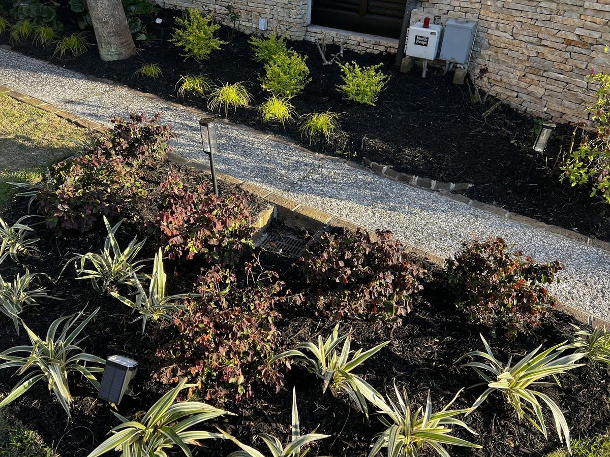 Planting bed with landscape lights beside a gravel path, installed by Prestige Landscaping