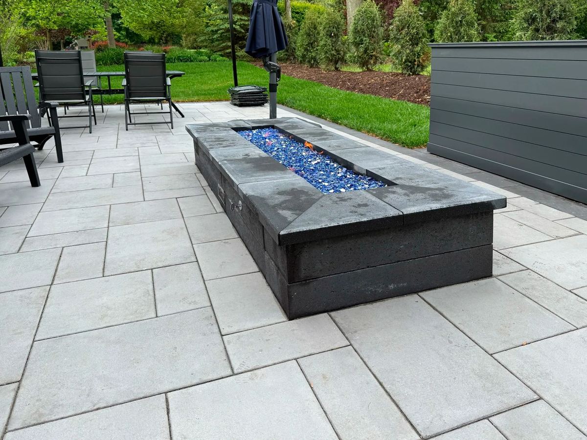 Modern patio with a linear gas fire table and lounge chairs