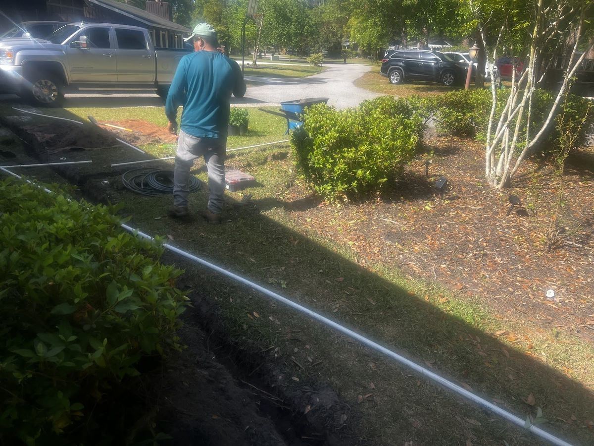 Prestige Landscaping crew member laying out irrigation line in a residential yard