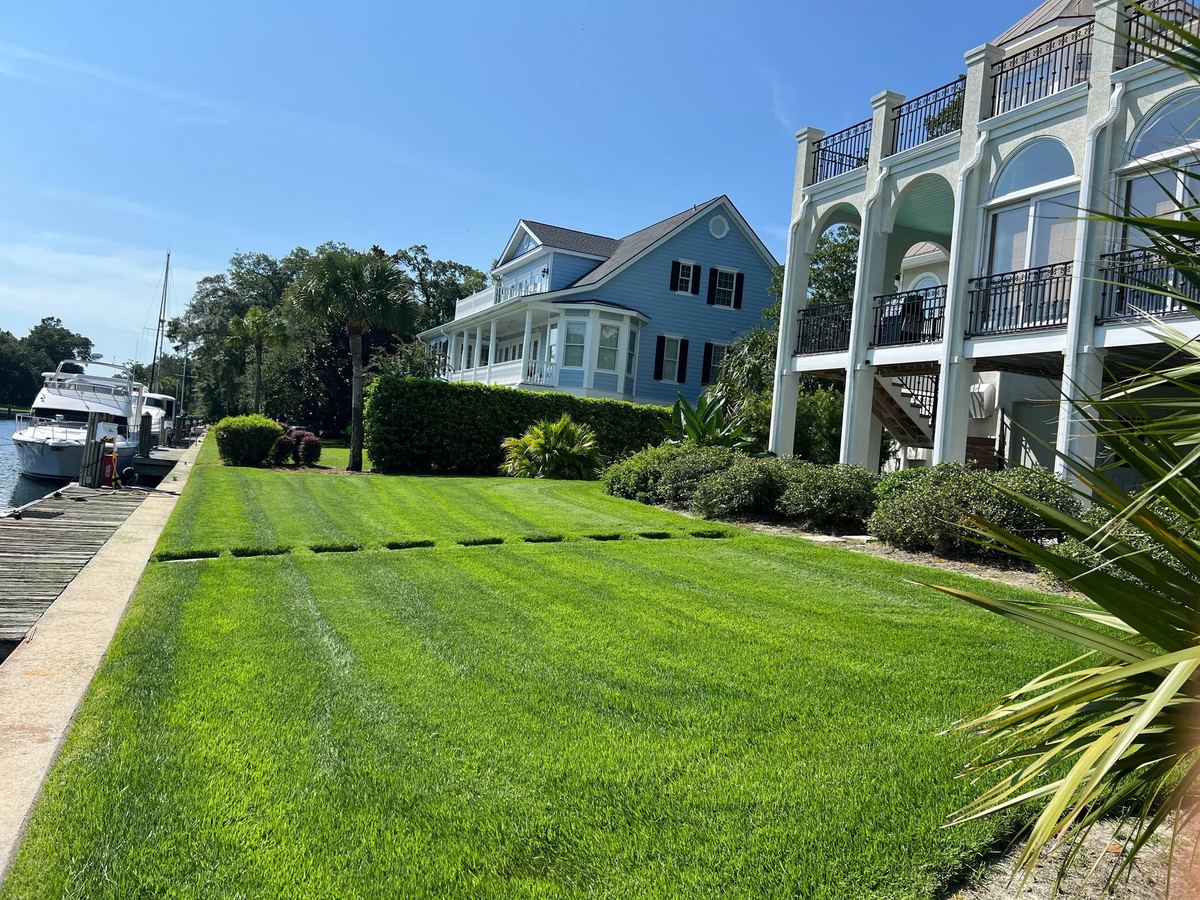 Freshly mowed striped lawn beside waterfront homes